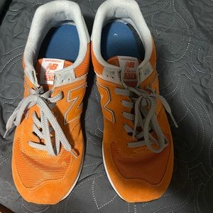 Men’s New Balance 574 athletic shoes. Size 13. Color is orange and white.